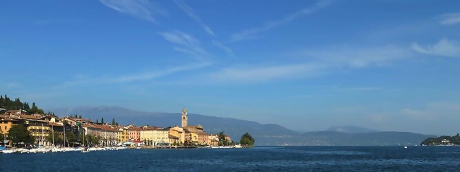Trip La Gomera beliebte Urlaubsziele am Gardasee -  Mit einer Fläche von 370 km² ist der Gardasee der größte See Italiens. Es liegt am Fuße der Alpen und erstreckt sich über drei Staaten: Lombardei, Venetien und Trentino. Die maximale Tiefe des Sees beträgt 346 m, er hat eine längliche Form und sein nördliches Ende ist sehr schmal. Dort ist der See von den Bergen der Gruppo di Baldo umgeben. Du trittst aus deinem gemütlichen Hotelzimmer und es begrüßt dich die warme italienische Sonne. Du blickst auf den atemberaubenden Gardasee, der in zahlreichen Blautönen schimmert - von tiefem Dunkelblau bis zu funkelndem Türkis. Majestätische Berge umgeben dich, während die Brise sanft deine Haut streichelt und der Duft von blühenden Zitronenbäumen deine Nase kitzelt. Du schlenderst die malerischen, engen Gassen entlang, vorbei an farbenfrohen, blumengeschmückten Häusern. Vereinzelt unterbricht das fröhliche Lachen der Einheimischen die friedvolle Stille. Du fühlst dich wie in einem Traum, der nicht enden will. Jeder Schritt führt dich zu neuen Entdeckungen und Abenteuern. Du probierst die köstliche italienische Küche mit ihren frischen Zutaten und verführerischen Aromen. Die Sonne geht langsam unter und taucht den Himmel in ein leuchtendes Orange-rot - ein spektakulärer Anblick.